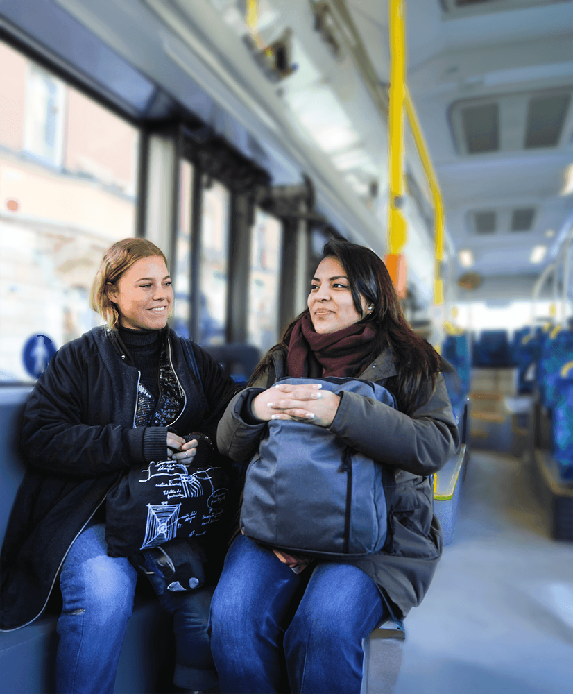 Foto på två kvinnor som sitter på en buss.