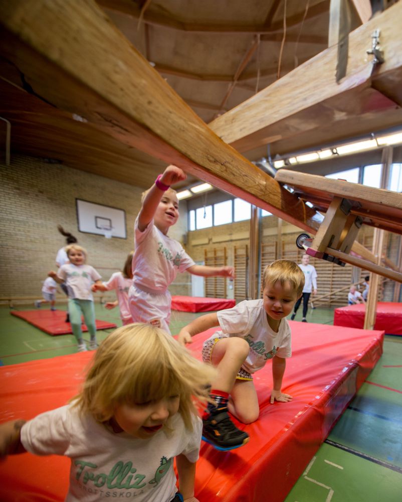 Barn som har gymnastik i en idrottshall.