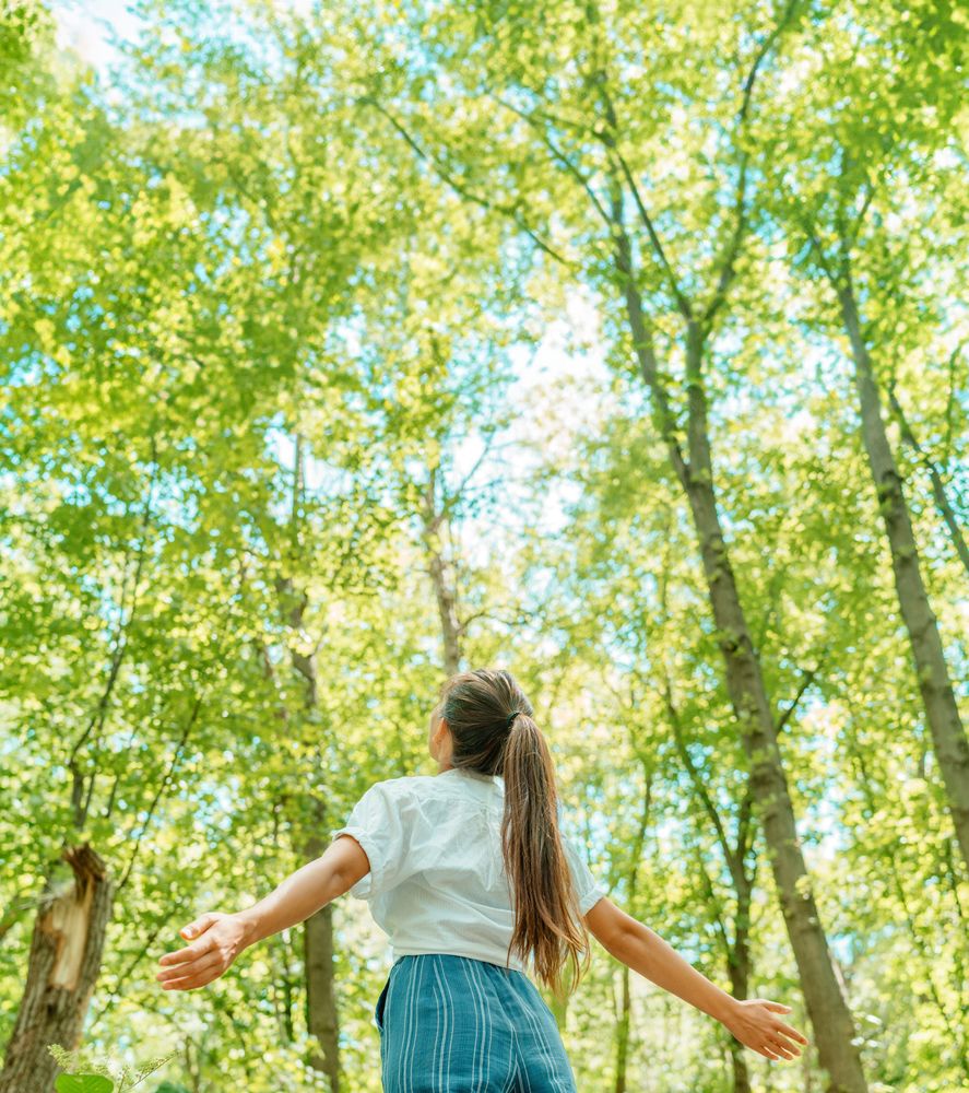 Foto på en flicka i en lövskog