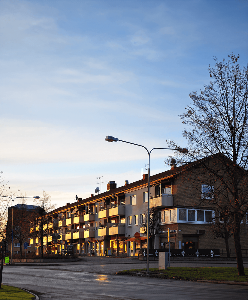 Foto över byggnader längs Stationsgatan i Kolbäck i solnedgång.